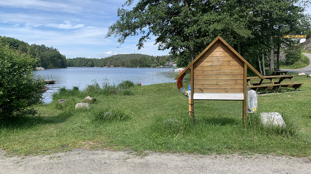 Bilde av Hananbukta. Grus, vann, oppslagstavle.